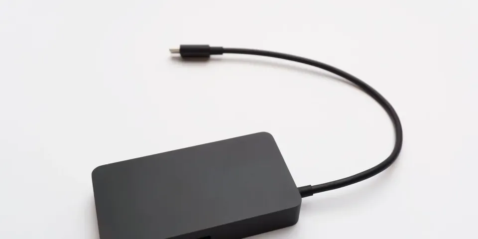 Schlanke portable Festplatte mit angeschlossenem Kabel auf weißem Hintergrund
