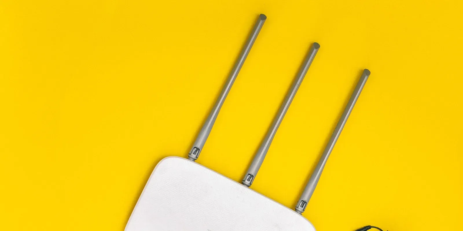Weißer WLAN-Router mit Antennen und angeschlossenen Kabeln