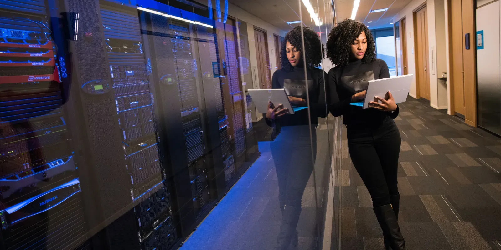 IT-Fachkraft mit Tablet vor Server-Racks als Symbol für Cloud-Daten und Microsoft-365-Backup