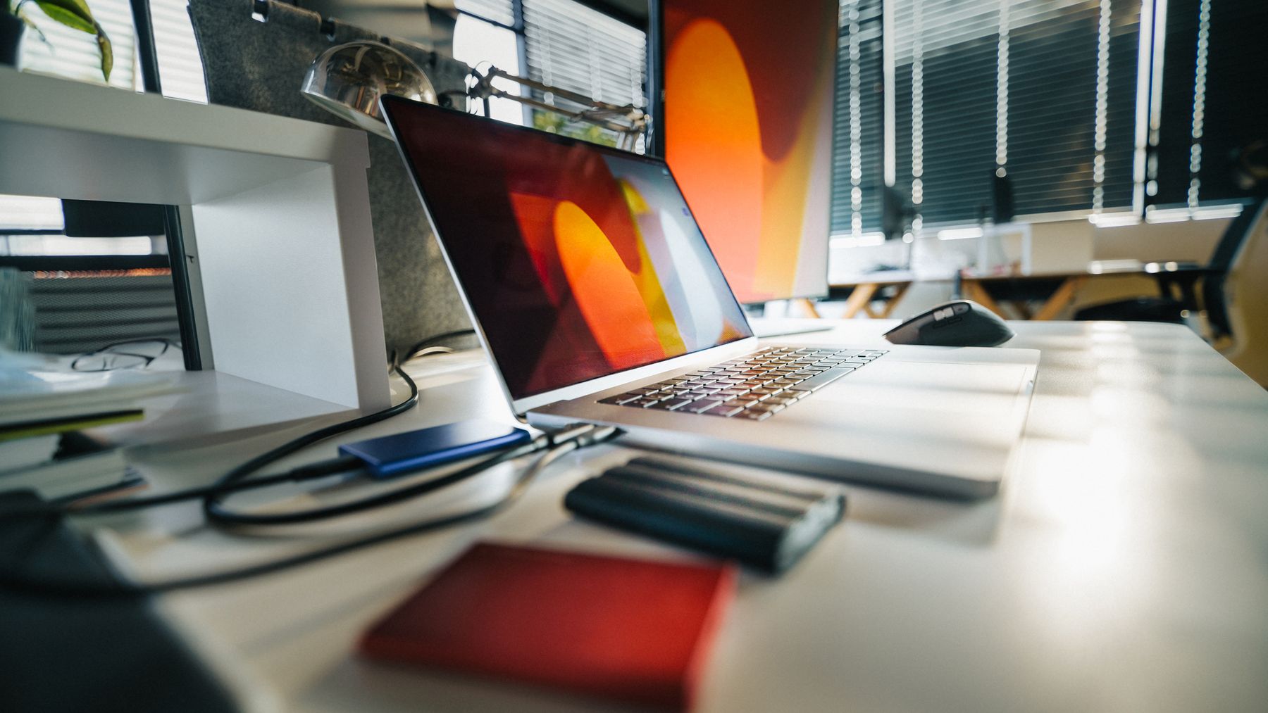 Moderner Büroarbeitsplatz mit Laptop und externen Datenträgern als Symbol für Backup und Wiederherstellung